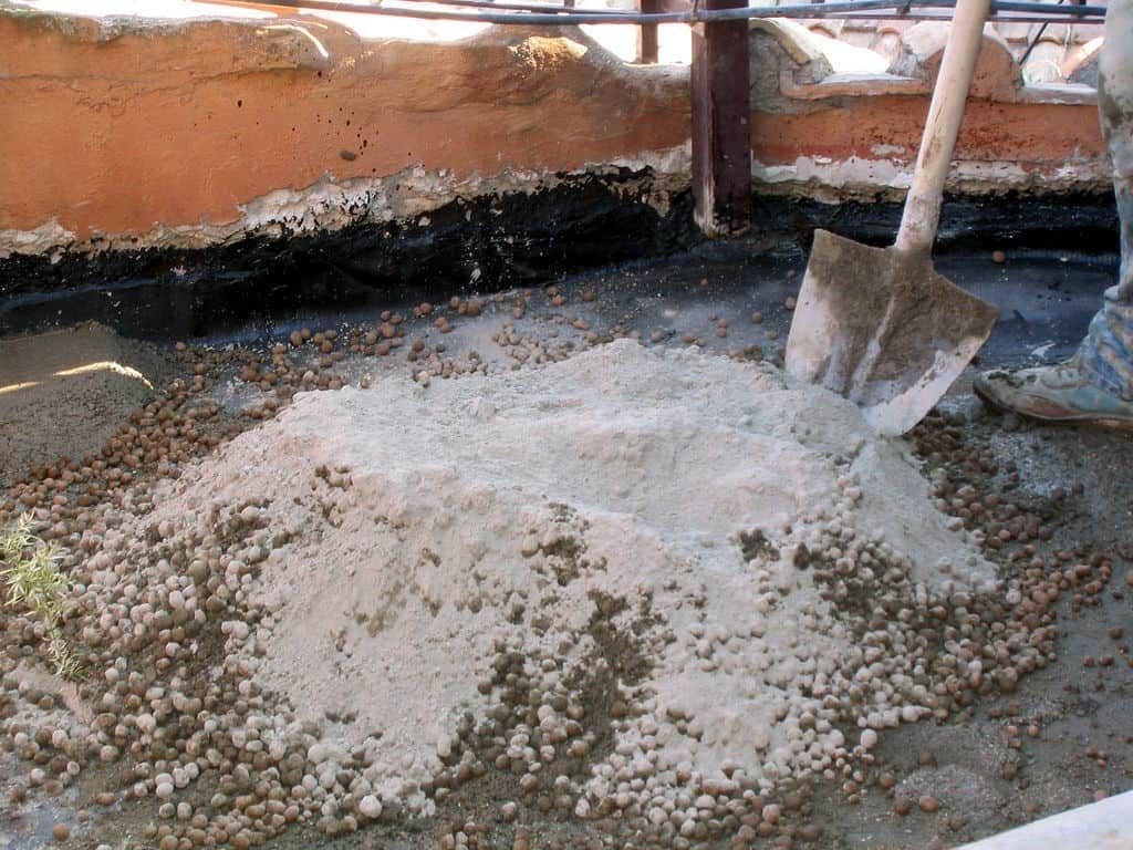 Builders mixing pumice pebbles with concrete - building with pumice