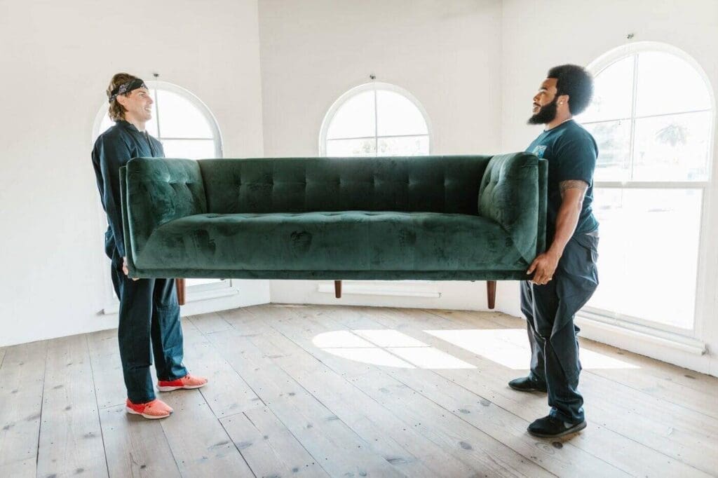 Two men moving sofa - how to make your house move more eco-friendly
