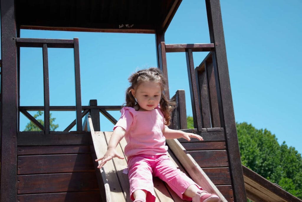 Girl sliding down from kids playhouse