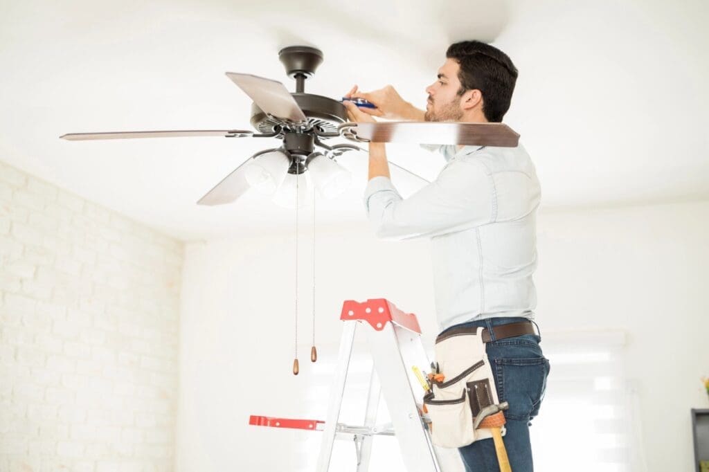 Handyman installing ceiling fan - energy myths debunked—and realities exposed