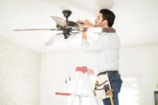Handyman installing ceiling fan - energy myths debunked—and realities exposed