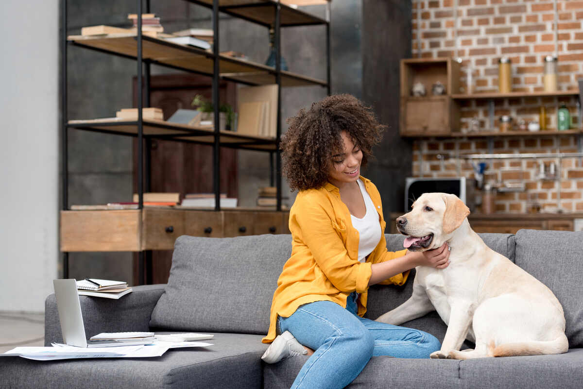How Interior Design Influences Wellbeing 7 Woman on couch with dog- in living room