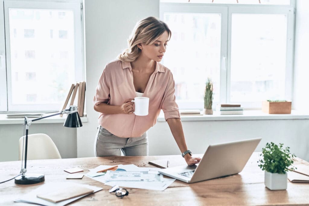 Woman leaning over desk in office